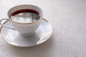 red colored tea in porcelain cup on white background
