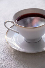 red colored tea in porcelain cup on white background
