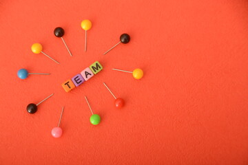 Alphabet beads with text TEAM. In a business context, a team refers to a group of individuals working collaboratively and cooperatively toward a common goal or objective.