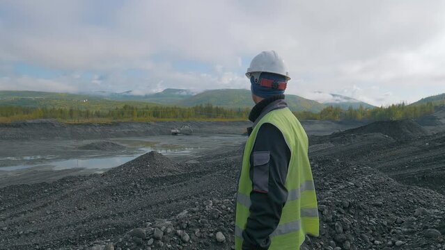 Surveyor supervises the gold metal excavation process at the mine. Surveyor observing the excavation machinery working at the mine. Surveyor monitoring the material excavation at the industrial mine.