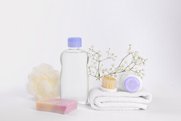 Different skin care products for baby in bottles, gypsophila and accessories on white background