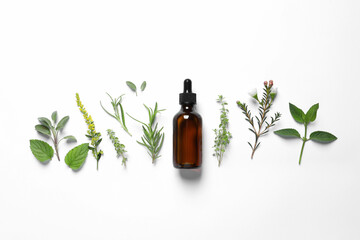 Bottle of essential oil and different herbs on white background, flat lay
