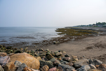 Fototapeta na wymiar A little coastal village on the foggy Saint Lawrence river