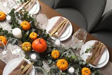 Obraz na płótnie Canvas Beautiful autumn table setting. Plates, cutlery, glasses, pumpkins and floral decor, above view