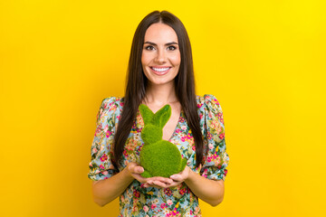 Photo of nice gorgeous woman with straight hairdo dressed flower print blouse arms hold green rabbit isolated on yellow color background - Powered by Adobe