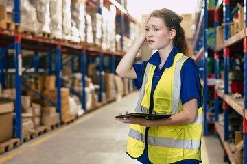Young girl warehouse employee shocked face while working mistake feel stressed anxiety and worry fear guilty gusture worker. - obrazy, fototapety, plakaty