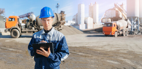 Concrete plant industry Banner. Industrial Worker man in hard hat uses tablet background of cement mixer