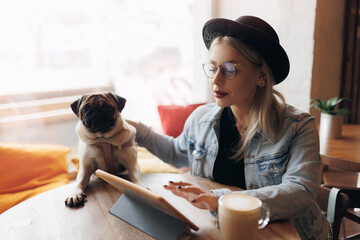 Lifestyle pug and owner Happy hipster woman use tablet for business startup. Freelancer work and...