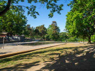 Empty childrens pond in park in summer with blue sky
