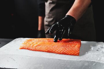 Close-up of chef hand prepared to cooking fresh salmon fille