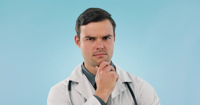 Healthcare, thinking or confused with a doctor man on a blue background in studio for diagnosis. Portrait, doubt and frown with a young medicine professional problem solving a health or medical issue