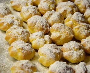 Fluffy profiteroles, cream puffs with vanilla cream and icing sugar. homemade dessert for dessert	