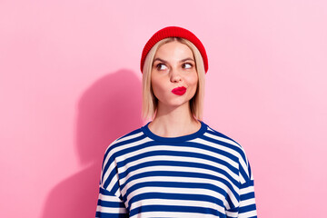 Photo of young blonde lady pouted red lips wearing beanie hat striped pullover look novelty thoughtful isolated on pink color background