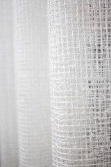 Obraz premium White curtains in the form of a mesh. Abstract background. Selective focus.