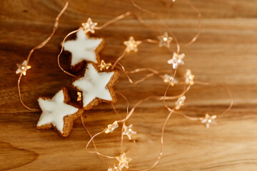 Gingerbread cookies in the shape of stars on a wooden brown natural table against a background of...