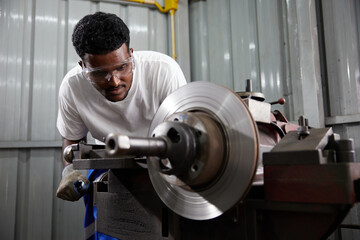 factory worker or technician working and control lathe machine in factory