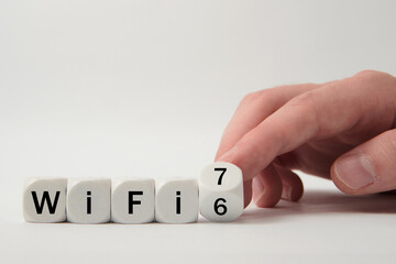 Hand turns dice and changes the expression "WiFi 6" to "WiFi 7" on white background
