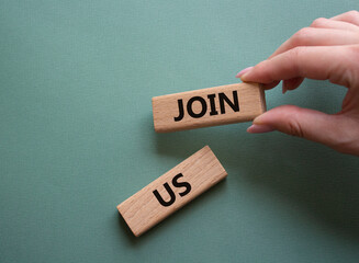 Join us symbol. Concept word Join us on wooden blocks. Beautiful grey green background. Businessman hand. Business and Join us concept. Copy space