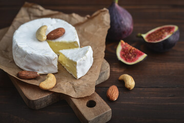 Camembert cheese with fresh figs on cutting board