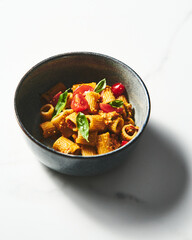 Sicilian Pesto Pasta. Pasta alla trapanese. Rigatoni pasta with pesto from cherry tomatoes and blanched almonds, basil and garlic plus anchovies and chili.