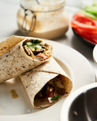 Beef and Lamb Lebanese style shawarma with onions, greens and vegetables such cucumber and tomato. all seasoned with tahini and garlic sauce and wrapped in pita or pita bread.