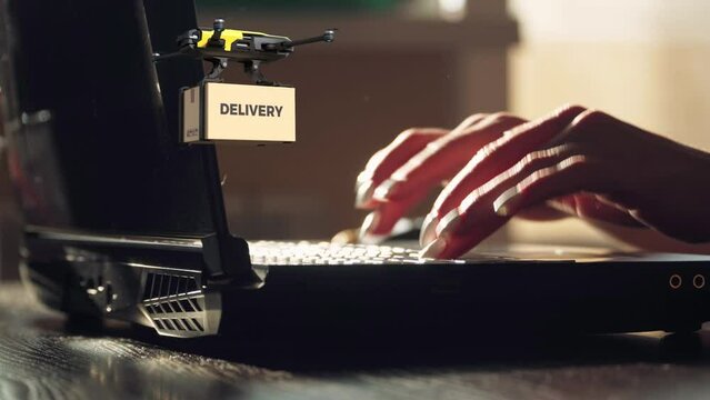 Mujer de negocios tipeando en su laptop, realizando env&iacute;os. Drone volando llevando una caja que dice Delivery.