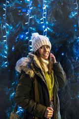 Girl smiling next to a Christmas tree.