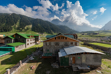 Fototapeta na wymiar Traditional houses with beautiful scenic view of clouds and mountains in background at Old Manali in India
