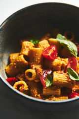 Sicilian Pesto Pasta. Pasta alla trapanese. Rigatoni pasta with pesto from cherry tomatoes and blanched almonds, basil and garlic plus anchovies and chili.