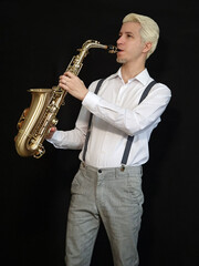 Blonde saxophonist man wearing white shirt playing golden saxophone. Photo with black background.