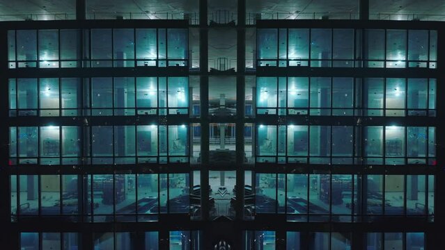 Aerial descending footage of construction of modern high rise office or residential building at dusk. Abstract computer effect digital composed footage