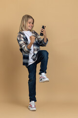 Teen girl with a phone in hands feeling excited and enjoyed