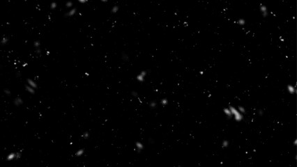 Fototapeta na wymiar Winter night snowfall and blizzard. Snowfall bokeh on black background. Many snowflakes in flying in the air.