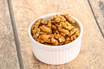 Cracked unshelled walnut in the bowl