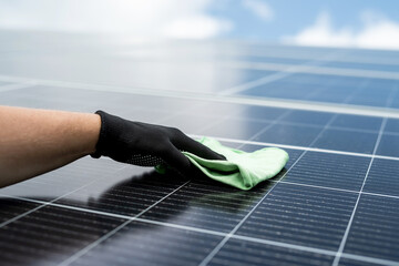 hand cleaning surface of photovoltaic panels with microfiber cloth to clean dirty and dusty