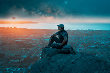 silhouette latin mature man sitting on top of the hill contemplating the moon on the horizon over the city © oscargutzo