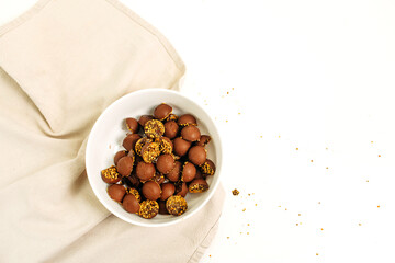 Chocolate keto candies in a white plate on the table.