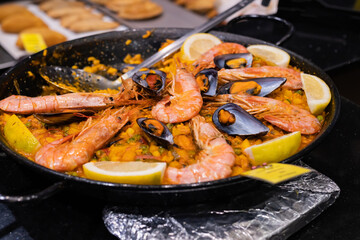 Top view of a freshly made Spanish paella of rice and fresh seafood, selective focus on prawns, Spanish gastronomy concept