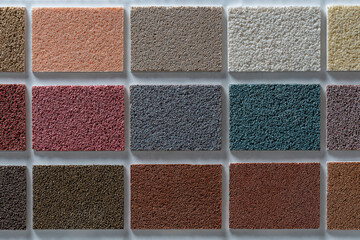 Samples of multi colored plaster for the decoration of the facade and interior of buildings, color palette. Presentation of building materials on background, closeup, top view