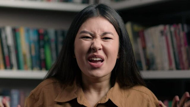 Angry furious stressed asian woman shouting irritated emotion in university library korean girl female student shout scream yelling crazy mad client arguing screaming feel anger stress rage aggression