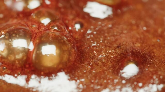 Close up of boiling sugar with bubbles turns into caramel, caramelization, chef cooking dessert in cafe, restaurant pastry food.