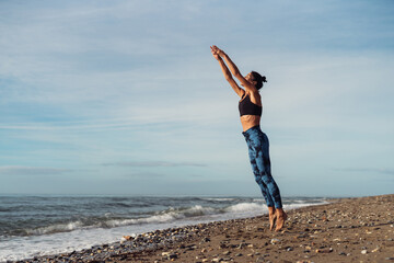Obraz premium The girl is doing fitness on the seaside.