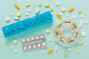 Daily pill box with medications on color background, top view
