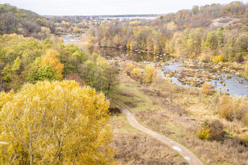 Autumn, river with stone rapids. Trees.