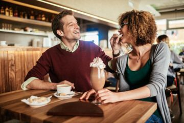Young couple feeding each other in a cafe