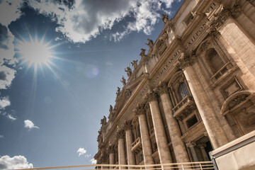 Blue sky, sun and white clouds over the Basilica of St. Peter in Rome, Italy.