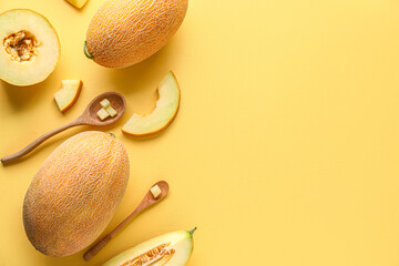 Sweet melons and wooden spoons with pieces on yellow background