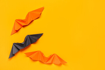 Different origami bats on orange background - obrazy, fototapety, plakaty