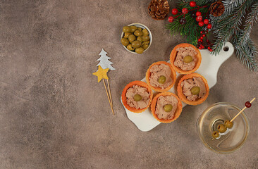 Christmas and New Year's dishes, a set of snacks and refreshing drinks for the holiday table. Plate with tartlets of pate, cheese and olives on a concrete table,