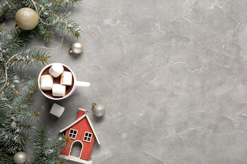 Cup of tasty cocoa with marshmallows and Christmas decor on grey background